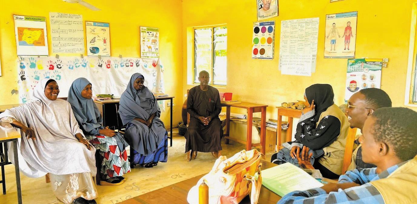 ZAIDF team members meet teachers and staff in a school classroom