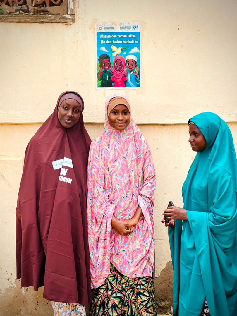 Three women pose together after a hygiene education session